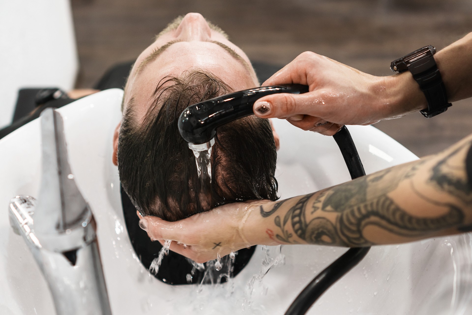 Washing hair to man in barbershop.